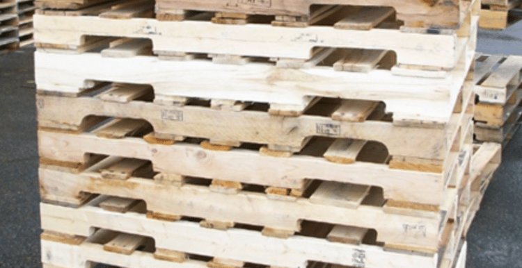Whitewood stringer pallets stacked inside warehouse